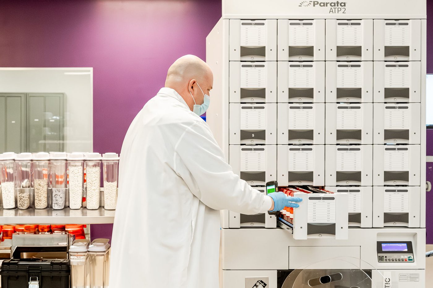 A technician working at automated dispensing equipment in a US facility